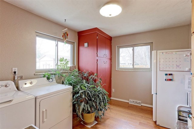 laundry area featuring plenty of natural light, cabinet space, independent washer and dryer, and visible vents