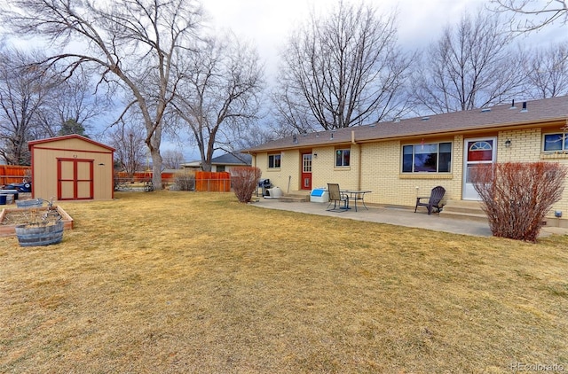 view of yard featuring entry steps, a patio, a fenced backyard, a storage unit, and an outdoor structure