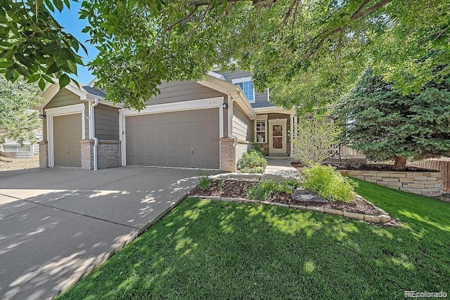 view of front of house featuring driveway, an attached garage, a front lawn, and brick siding