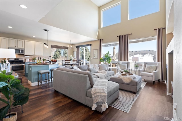 living room with a notable chandelier, dark wood finished floors, and recessed lighting