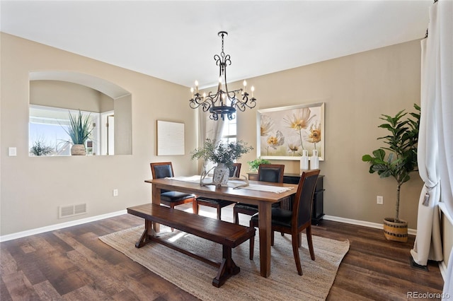 dining room featuring a chandelier, dark wood-style flooring, visible vents, and baseboards