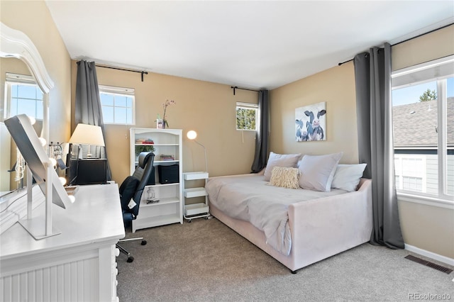 bedroom featuring multiple windows, carpet flooring, and visible vents