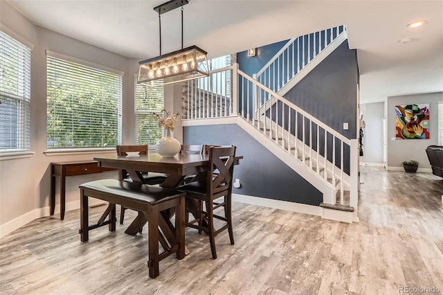 8317 Liverpool Cir, Littleton, CO 80125 - dining room with stairs, wood finished floors, baseboards, and a chandelier