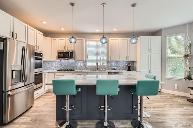 8317 Liverpool Cir, Littleton, CO 80125 - kitchen featuring stainless steel appliances, a sink, backsplash, a center island, and recessed lighting
