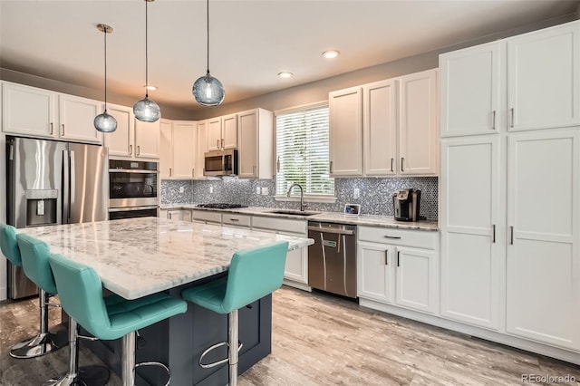8317 Liverpool Cir, Littleton, CO 80125 - kitchen featuring stainless steel appliances, a sink, a breakfast bar, backsplash, and light stone counters