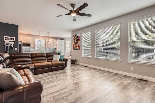 8317 Liverpool Cir, Littleton, CO 80125 - living room featuring a ceiling fan, baseboards, light wood-style flooring, and recessed lighting
