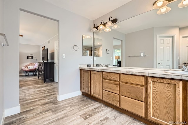 8317 Liverpool Cir, Littleton, CO 80125 - full bath with wood finished floors, double vanity, and baseboards