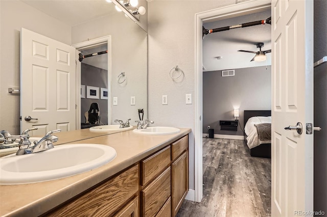 8317 Liverpool Cir, Littleton, CO 80125 - bathroom with ensuite bath, wood finished floors, double vanity, and a ceiling fan