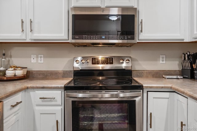 5800 Tower Rd Unit 610, Denver, CO 80249 - kitchen featuring appliances with stainless steel finishes, white cabinetry, and light countertops