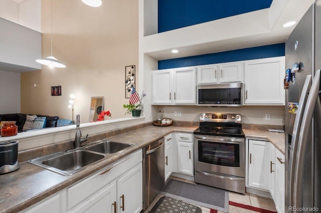 5800 Tower Rd Unit 610, Denver, CO 80249 - kitchen featuring stainless steel appliances, white cabinets, and a towering ceiling