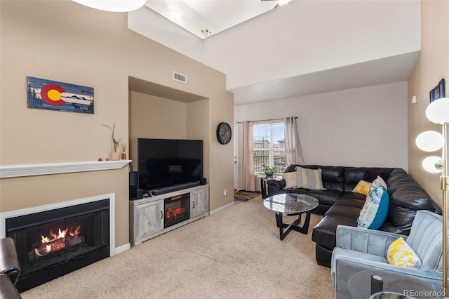 5800 Tower Rd Unit 610, Denver, CO 80249 - carpeted living room featuring a lit fireplace and baseboards