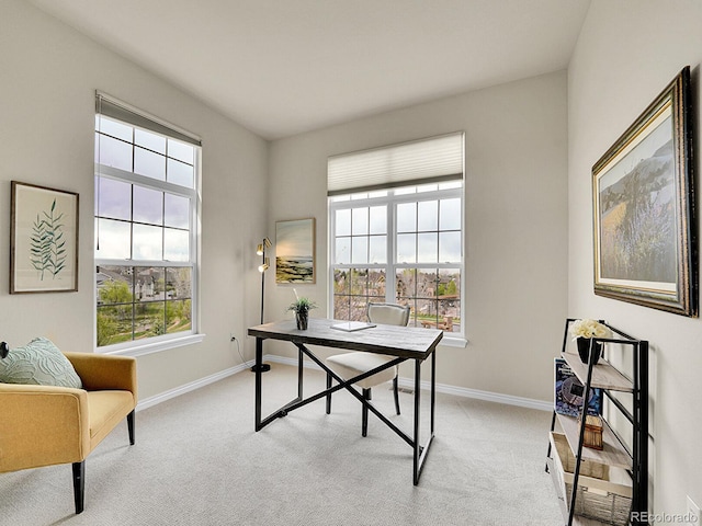 office space featuring baseboards, plenty of natural light, and light colored carpet