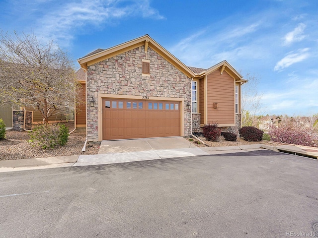 view of front of property featuring a garage and stone siding