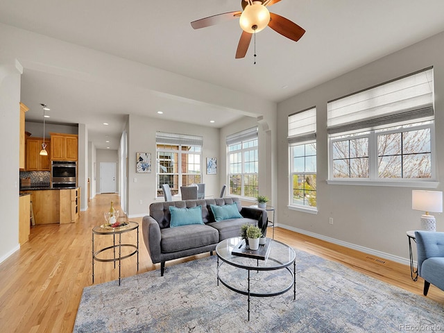 living area featuring visible vents, baseboards, ceiling fan, recessed lighting, and light wood finished floors