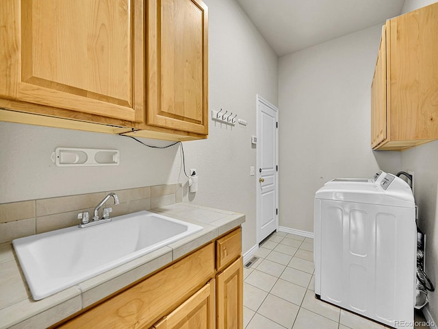 laundry room featuring cabinet space, light tile patterned flooring, a sink, and washing machine and clothes dryer