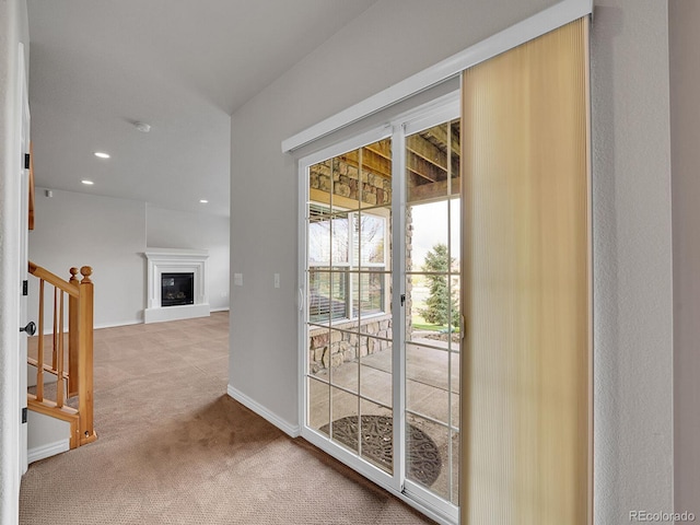 doorway with carpet flooring, a glass covered fireplace, recessed lighting, baseboards, and stairway