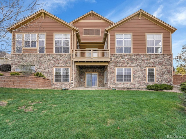 back of property featuring a yard and stone siding
