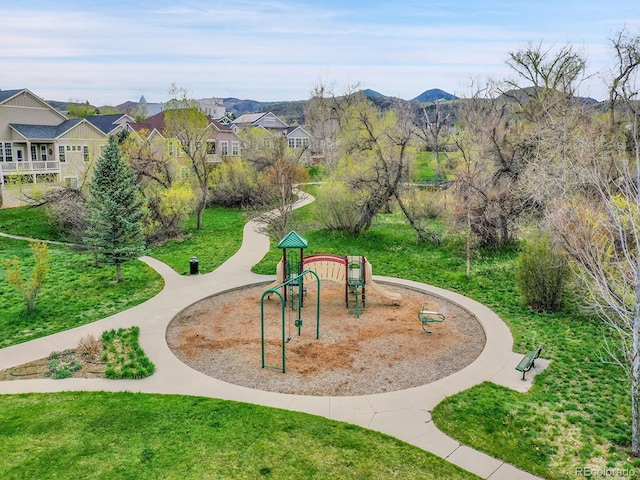 surrounding community featuring a lawn, a mountain view, playground community, and a residential view