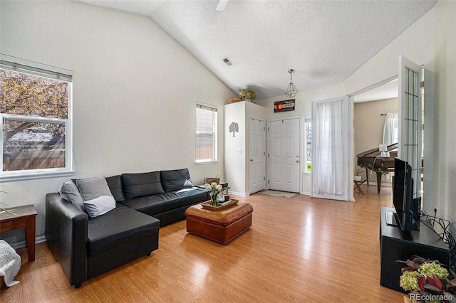 20137 E Prentice Pl, Centennial, CO 80015 - living room featuring visible vents, a textured ceiling, light wood finished floors, and lofted ceiling