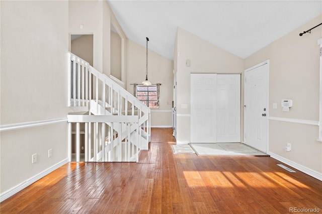 entrance foyer with hardwood / wood-style floors and vaulted ceiling