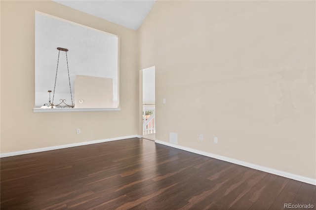 empty room featuring wood-type flooring and vaulted ceiling