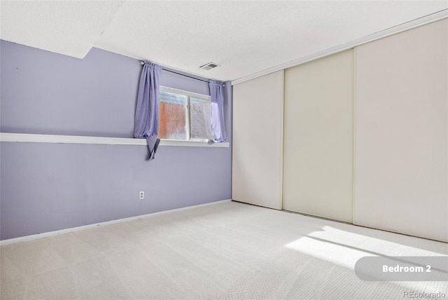 carpeted empty room with a textured ceiling