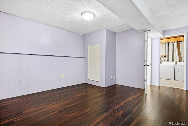 empty room with a textured ceiling, dark hardwood / wood-style flooring, and independent washer and dryer