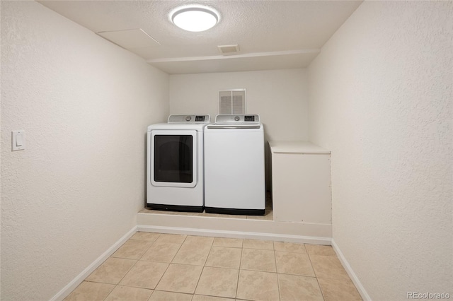 4972 Easley Rd, Golden, CO 80403 - laundry area with washing machine and dryer, light tile patterned floors, baseboards, a textured wall, and a textured ceiling