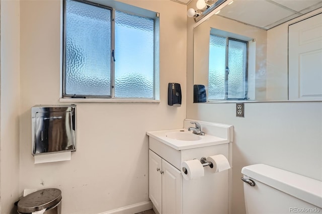 bathroom featuring vanity, a wealth of natural light, and toilet