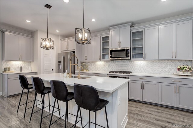 431 Courtfield Way, Castle Pines, CO 80108 - kitchen with stainless steel appliances, gray cabinetry, a chandelier, tasteful backsplash, and recessed lighting
