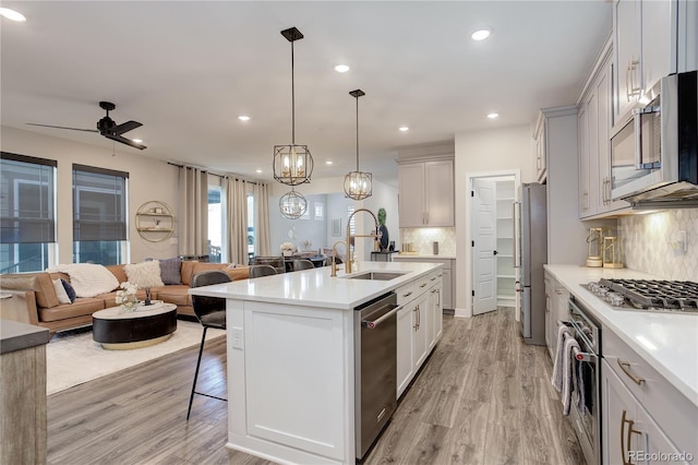 431 Courtfield Way, Castle Pines, CO 80108 - kitchen with stainless steel appliances, a kitchen breakfast bar, open floor plan, backsplash, and light countertops