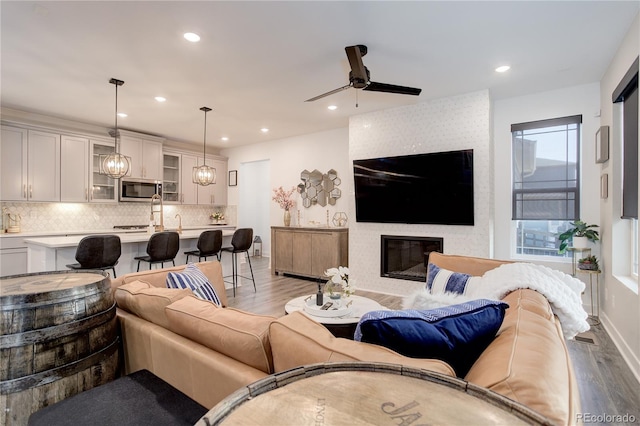 431 Courtfield Way, Castle Pines, CO 80108 - living room with wood finished floors, ceiling fan, recessed lighting, and a large fireplace