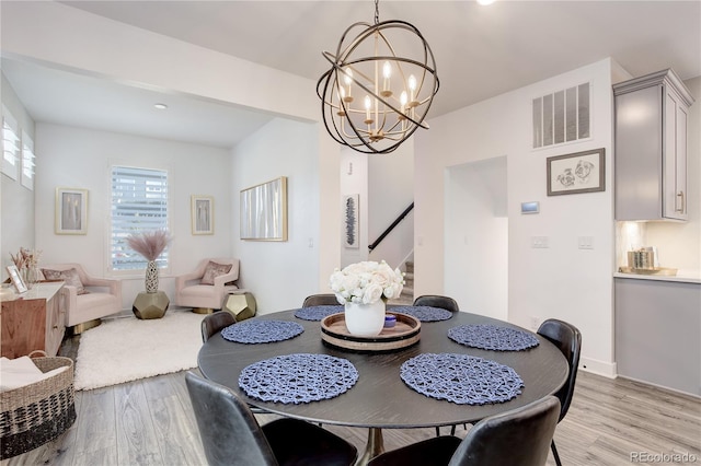 431 Courtfield Way, Castle Pines, CO 80108 - dining space featuring light wood-style flooring, a chandelier, and stairs