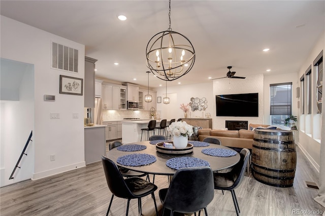 431 Courtfield Way, Castle Pines, CO 80108 - dining room featuring a chandelier, light wood-type flooring, ceiling fan, recessed lighting, and a fireplace