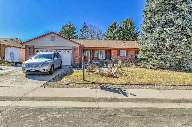 single story home with driveway, a garage, and brick siding