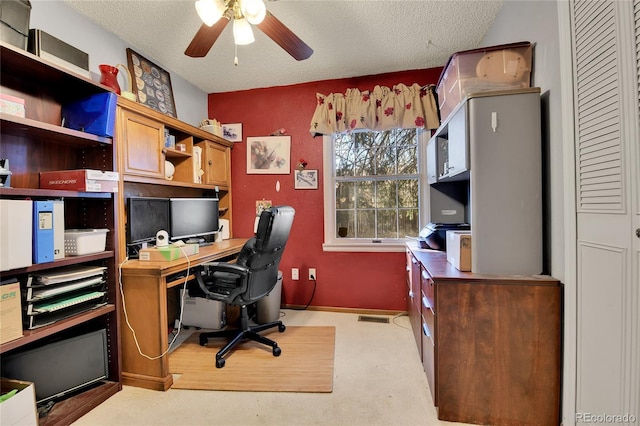 office with light carpet, ceiling fan, visible vents, and a textured ceiling