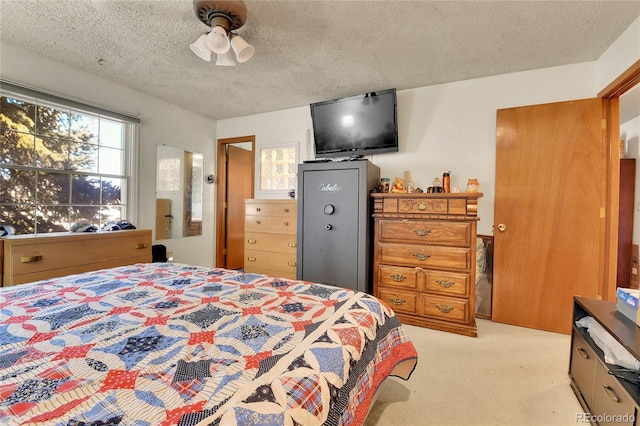 bedroom with light colored carpet, multiple windows, and a textured ceiling