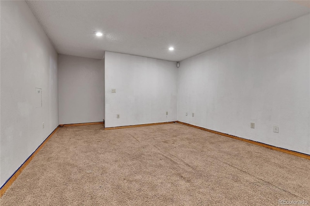 carpeted spare room featuring baseboards and recessed lighting