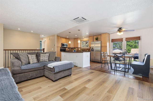 1246 S Telluride St, Aurora, CO 80017 - living area with light wood finished floors, a ceiling fan, a textured ceiling, and recessed lighting