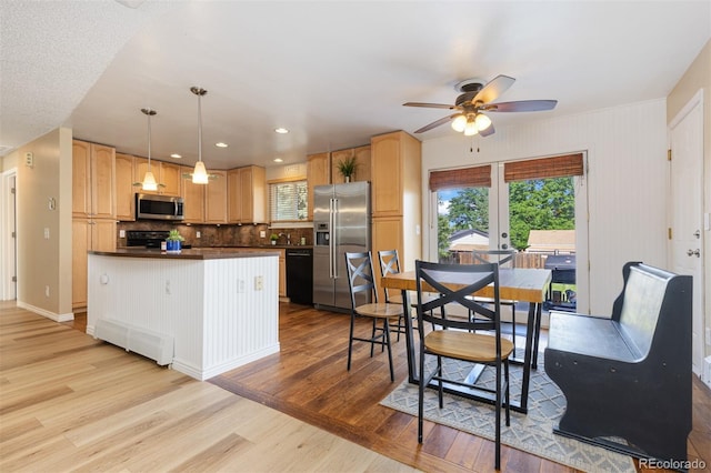 1246 S Telluride St, Aurora, CO 80017 - kitchen featuring stainless steel appliances, dark countertops, light wood-style flooring, ceiling fan, and backsplash