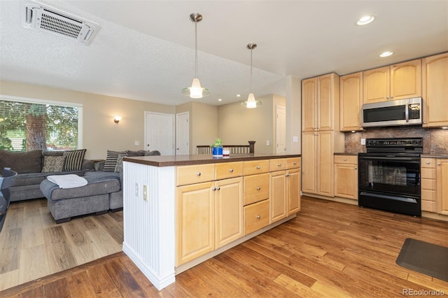 1246 S Telluride St, Aurora, CO 80017 - kitchen with stainless steel microwave, black electric range oven, light brown cabinets, dark countertops, and recessed lighting