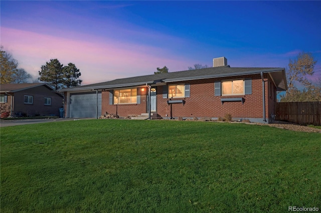 ranch-style home featuring a garage and a yard