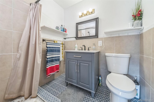 bathroom with vanity, tile patterned floors, tile walls, and curtained shower