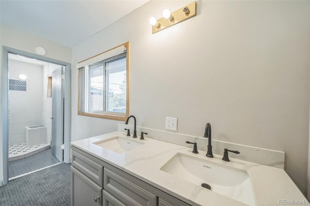 bathroom with tile patterned flooring, vanity, and walk in shower