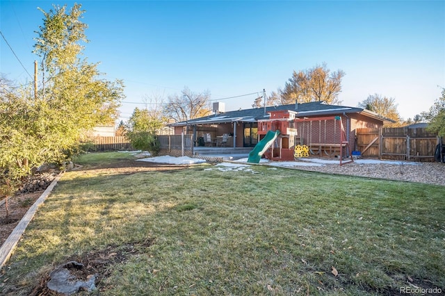 view of yard featuring a playground and a patio