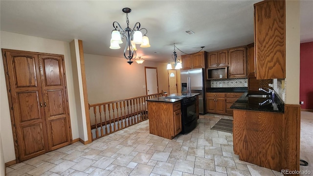 kitchen with pendant lighting, sink, stainless steel fridge, backsplash, and a center island