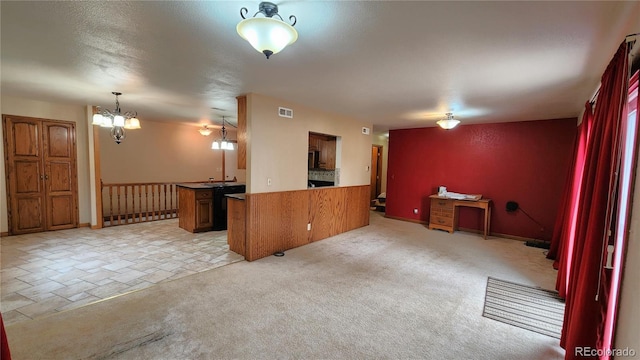 interior space with pendant lighting, light carpet, a notable chandelier, and kitchen peninsula