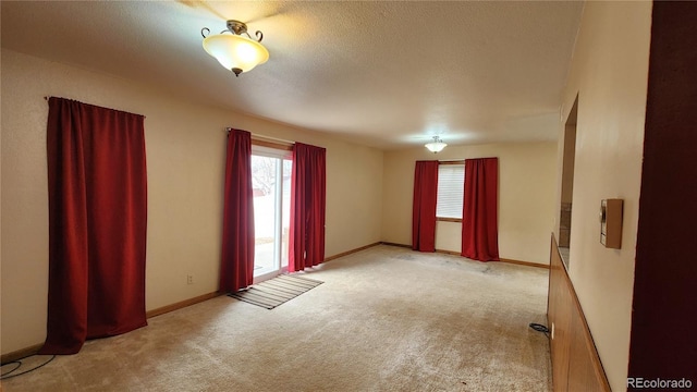 spare room featuring light colored carpet and plenty of natural light