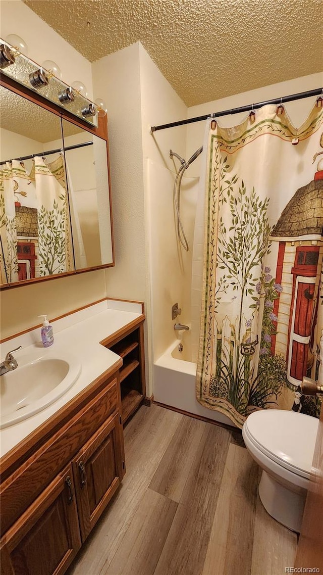 full bathroom featuring hardwood / wood-style floors, vanity, toilet, a textured ceiling, and shower / bath combo with shower curtain