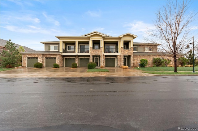 11364 Xavier Dr Unit 205, Westminster, CO 80031 - view of front of property featuring a garage, a balcony, stone siding, and concrete driveway